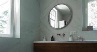 Le plan vasque en bois sur mur au marbre blanc et miroir rond